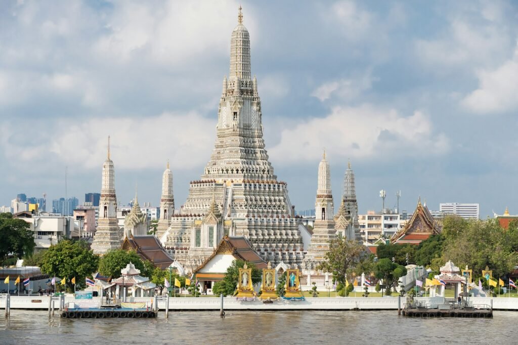 People walking near a historic building in Bangkok on a sunny day